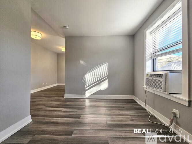 A room with a window and a wall-mounted air conditioner.