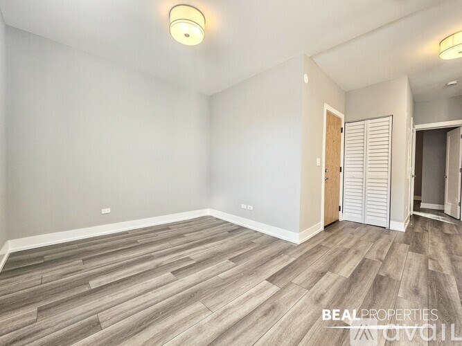 A room with wooden flooring and a white wall.