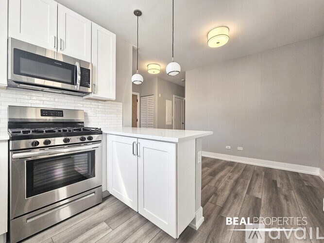 A modern kitchen with white cabinets and a stainless steel oven.