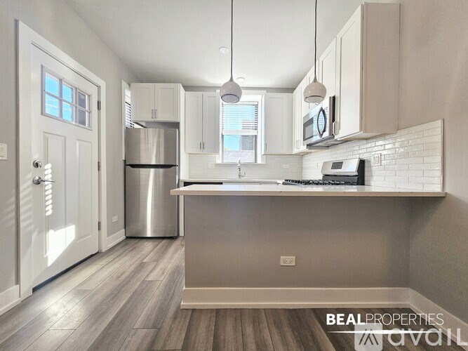 A kitchen with a refrigerator, stove, and microwave.