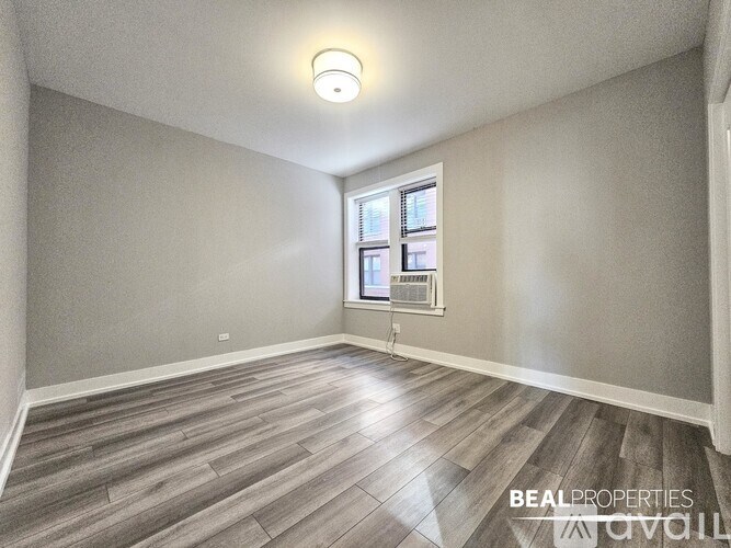 A room with a window and wooden flooring.