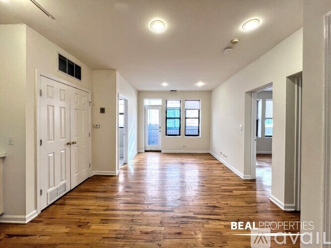 A spacious room with wooden floors and white walls.