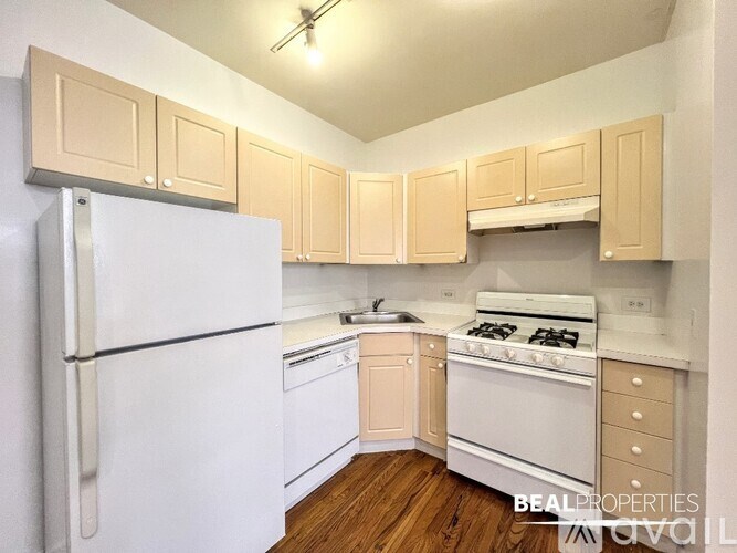 A kitchen with white appliances and wooden cabinets.