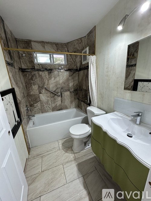A bathroom with a green sink and a bathtub with a shower curtain.