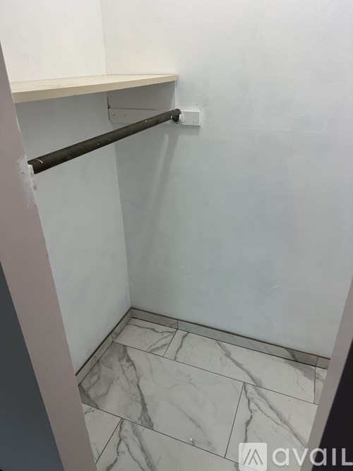 A white wall with a marble floor and a shelf.