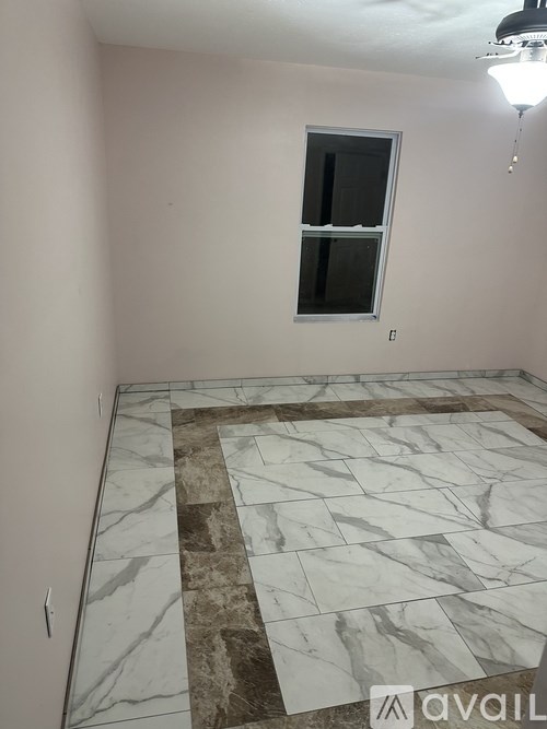 A room with a marble floor and a window.