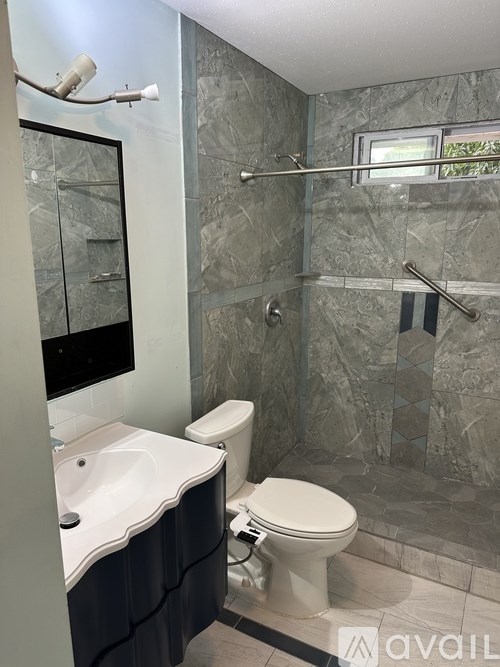 A bathroom with a toilet, sink, and a glass shower door.