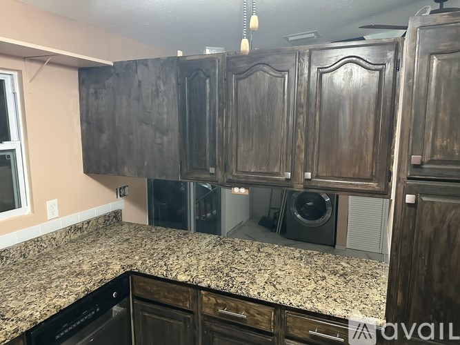 A kitchen with wooden cabinets and granite countertops.