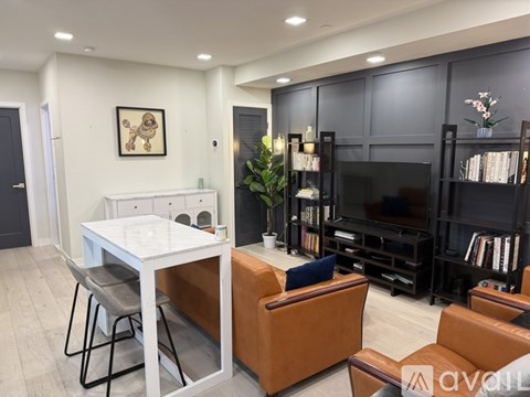 A living room with a white table and brown leather couch.