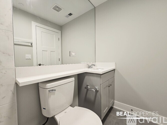 A white toilet with a white sink and a white cabinet.