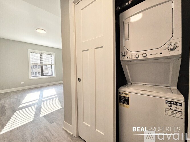 A white washing machine is in a room with a door and a window.