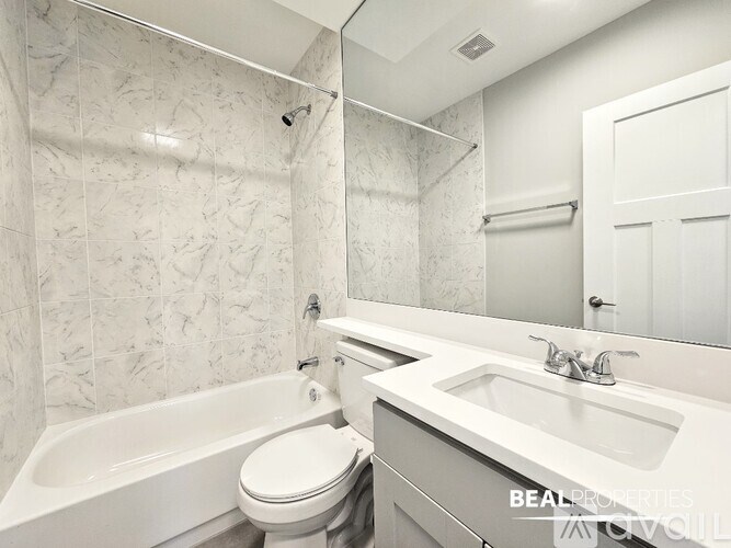 A white bathroom with a tub, toilet and sink.