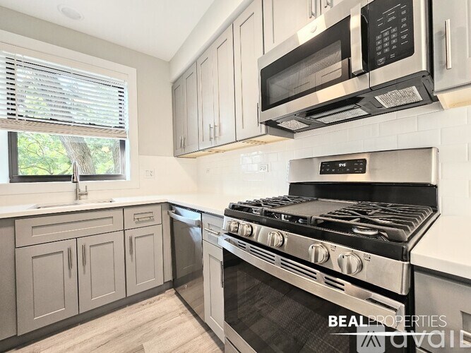 A kitchen with a stove, microwave, and oven.