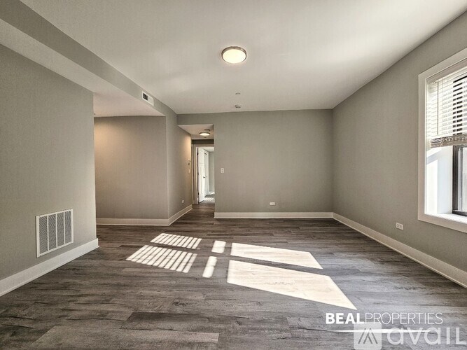 A spacious room with a carpeted floor and a window on the right side.