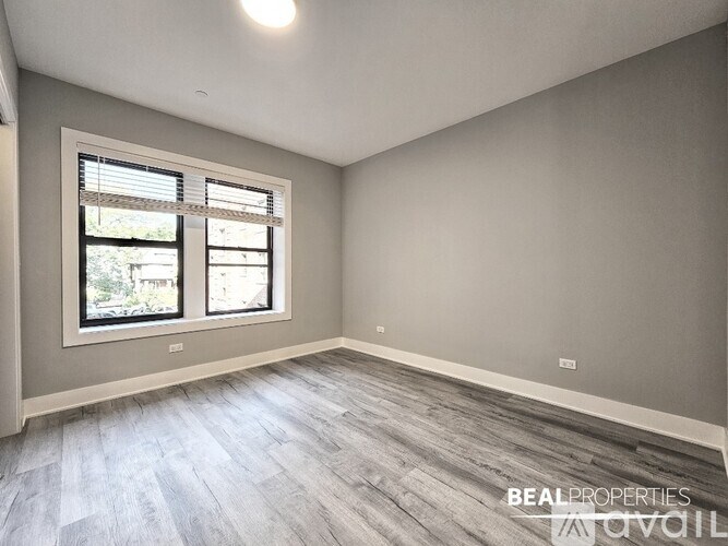 A room with a window and a wooden floor.