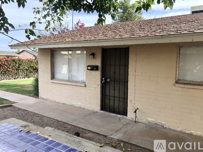 A house with a black door and a window with a white curtain.