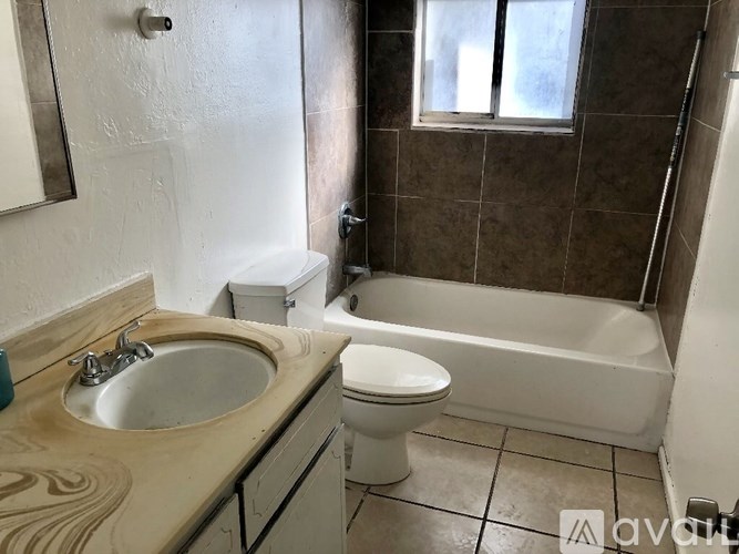 A bathroom with a toilet, sink, and bathtub.