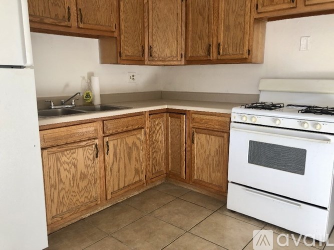 A kitchen with wooden cabinets and a white stove.