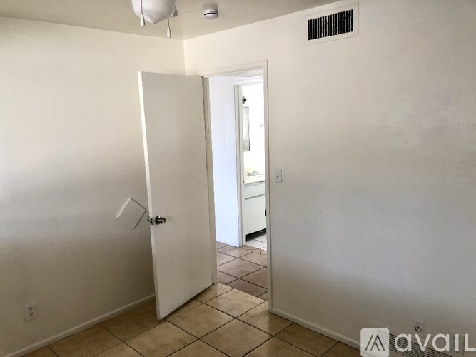 A room with a white door and a tiled floor.