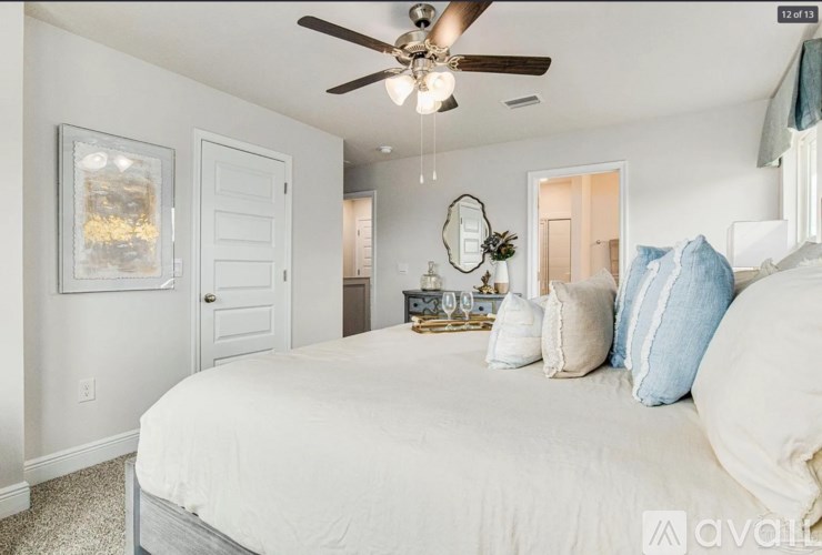 A bedroom with a large bed and a ceiling fan.