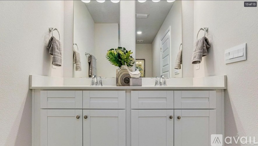 A bathroom with two sinks and a large mirror.