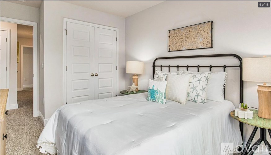 A bedroom with a white bed and a black metal headboard.