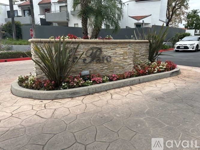 A stone sign with the letters "HFC" is surrounded by plants and flowers.