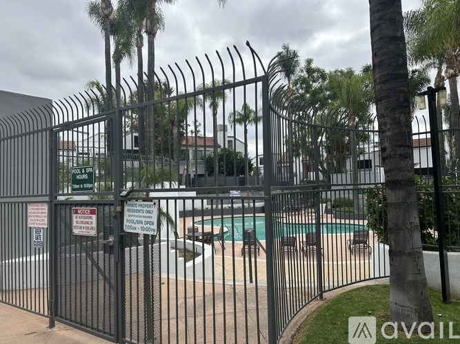 A black fence surrounds a pool with a sign that says "NO PUBLIC USE".
