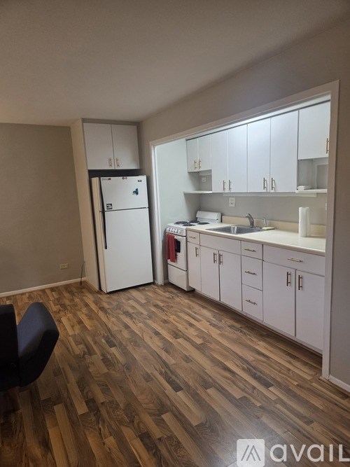 A kitchen with white cabinets and a wooden floor.