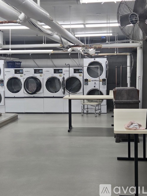 A laundromat with washing machines and a fan.