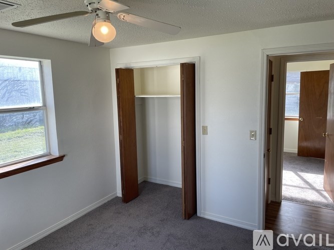 A room with a ceiling fan and a window.