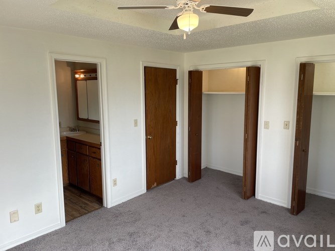 A room with a ceiling fan and a carpeted floor.