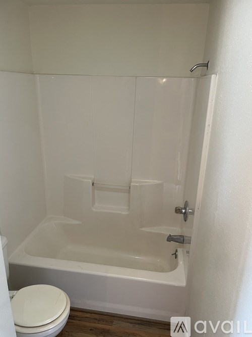 A white bathroom with a toilet and a bathtub.