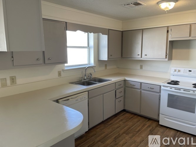 A kitchen with white appliances and cabinets.