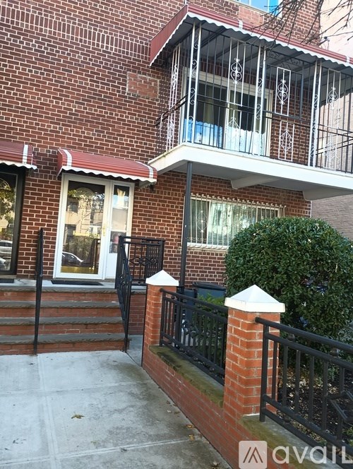 A red brick house with a black iron fence.