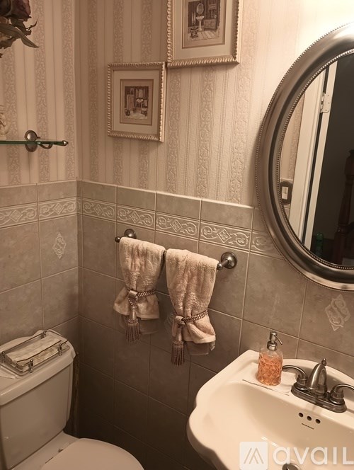 A bathroom with a toilet, sink, and towel rack.