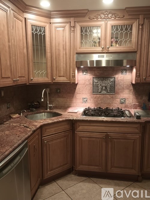 A kitchen with wooden cabinets and a granite countertop.