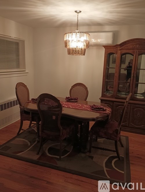 A dining room with a round table and chairs.