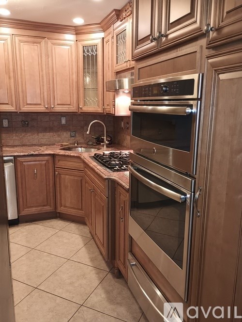 A kitchen with wooden cabinets and a stainless steel oven.