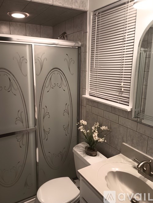 A bathroom with a toilet, sink, and decorative wall paneling.