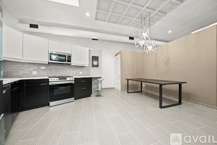 A modern kitchen with black appliances and white cabinets.
