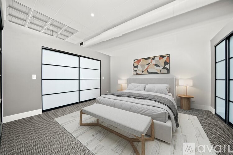 A bedroom with a large bed and a bench in front of it.