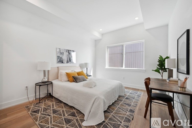 A bedroom with a bed, desk, and chair.