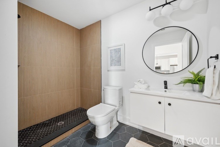 A bathroom with a toilet, sink, and mirror.