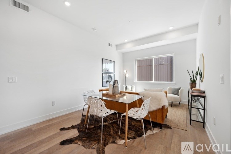 A room with a table and chairs and a cowhide rug.
