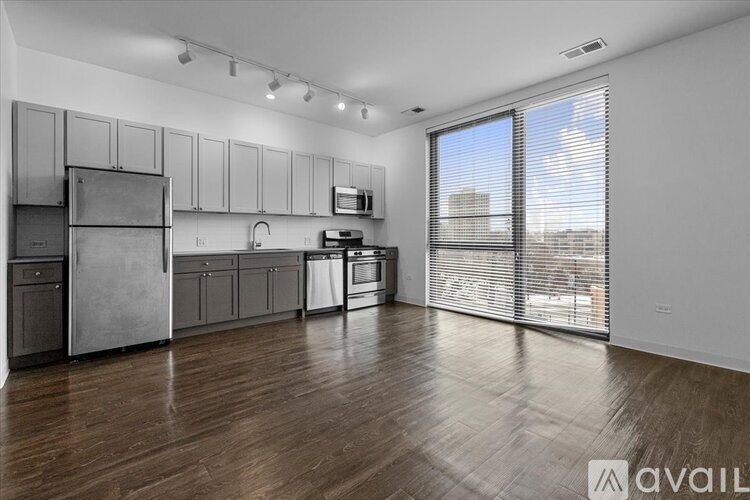 A spacious kitchen with wooden floors and stainless steel appliances.