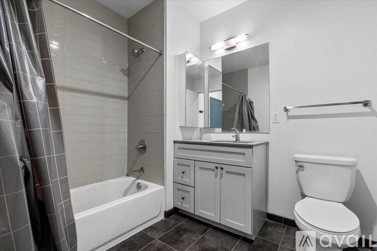A white bathroom with a white toilet, sink, and bathtub.