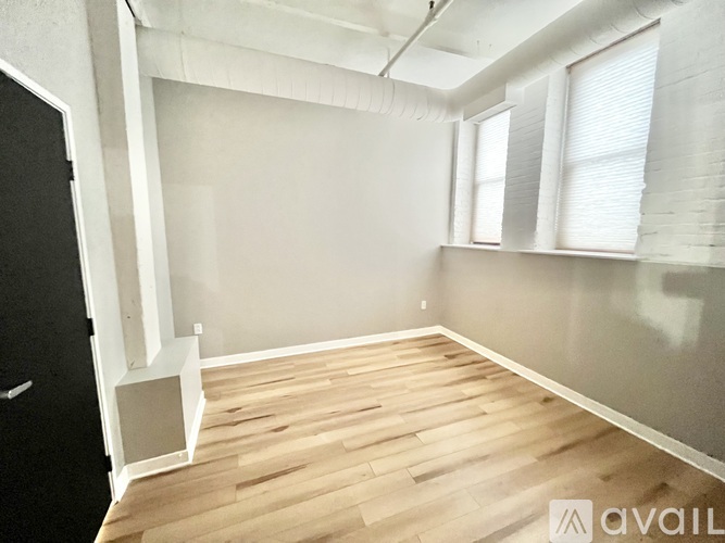 A room with wooden flooring and a black door.