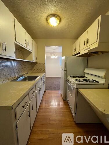 A kitchen with white cabinets and a wooden floor.