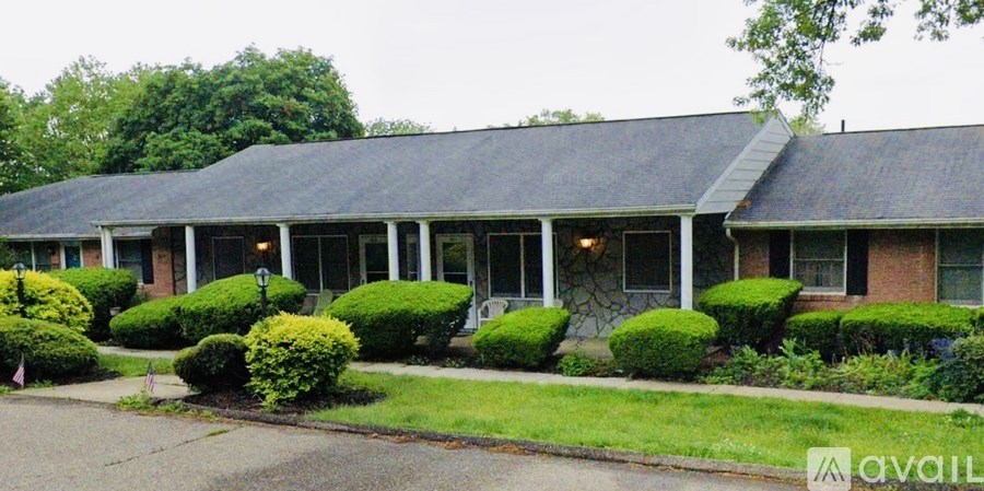 A house with a grey roof and a sign that says "available" in front of it.